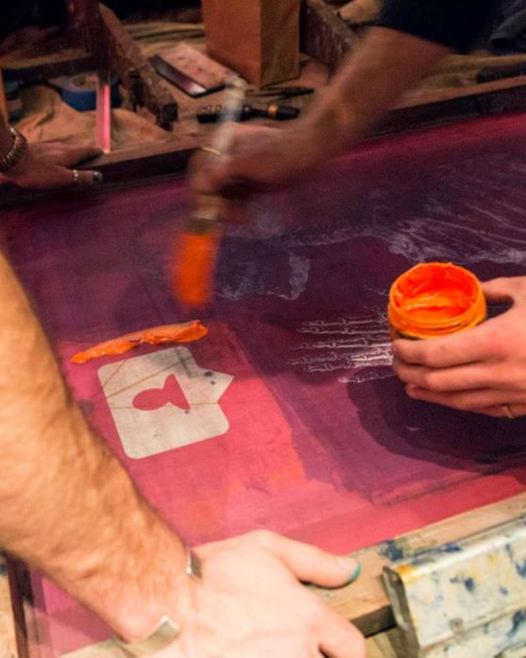 REMIX Summits — screen printing with orange ink at a summit workshop