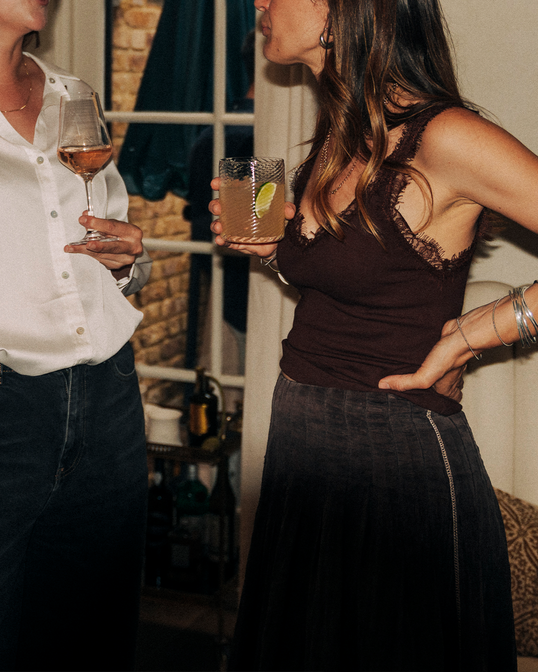 Two guests in conversation holding drinks at After Hours